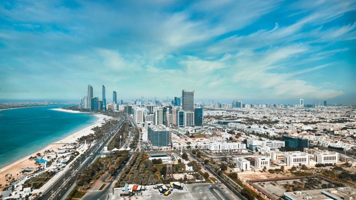 A breathtaking aerial view of Abu Dhabi's waterfront cityscape with modern high-rises and skyline.