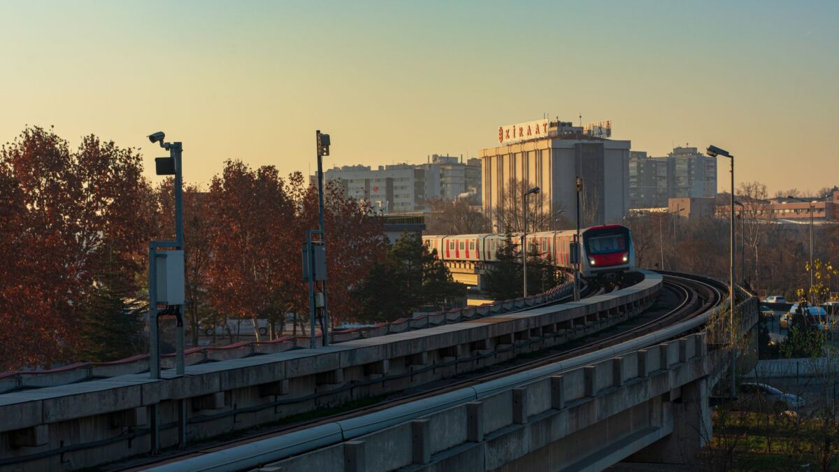 Railway bridge with a train at sunset in Ankara's urban landscape, Türkiye.