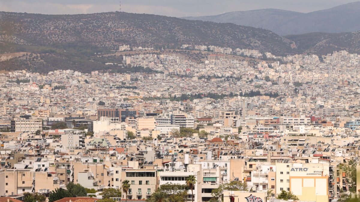 Expansive aerial view of Athens, Greece, showcasing urban architecture with a mountainous backdrop.