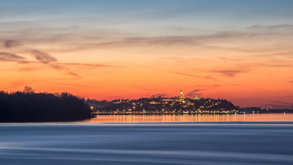 Serene sunrise view of Kalemegdan Fortress reflected on the river in Belgrade, Serbia.