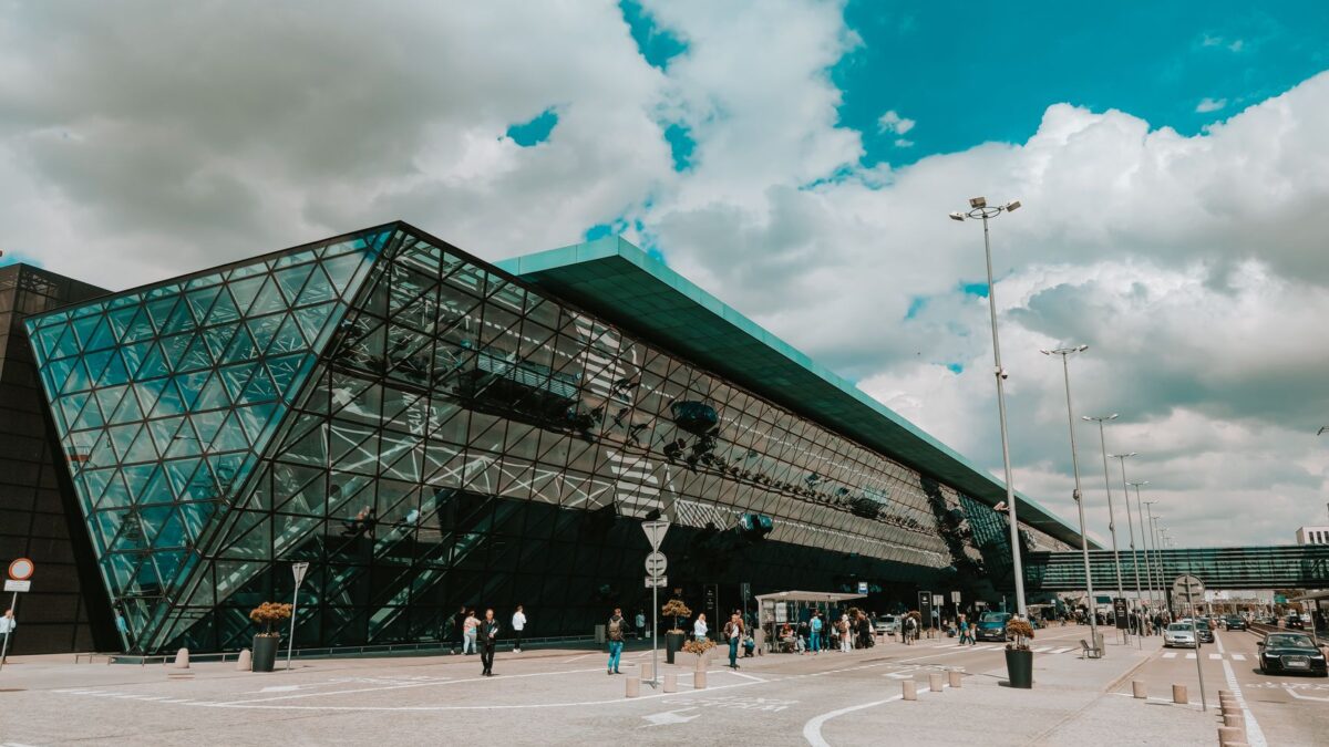 Contemporary airport terminal featuring striking glass facade under a cloudy sky.