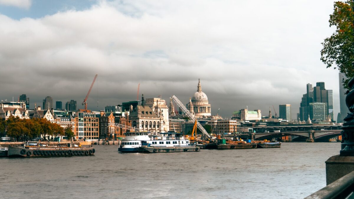 Beautiful view of the River Thames with St. Paul's Cathedral and London's skyline. Boats and cranes add vibrancy.
