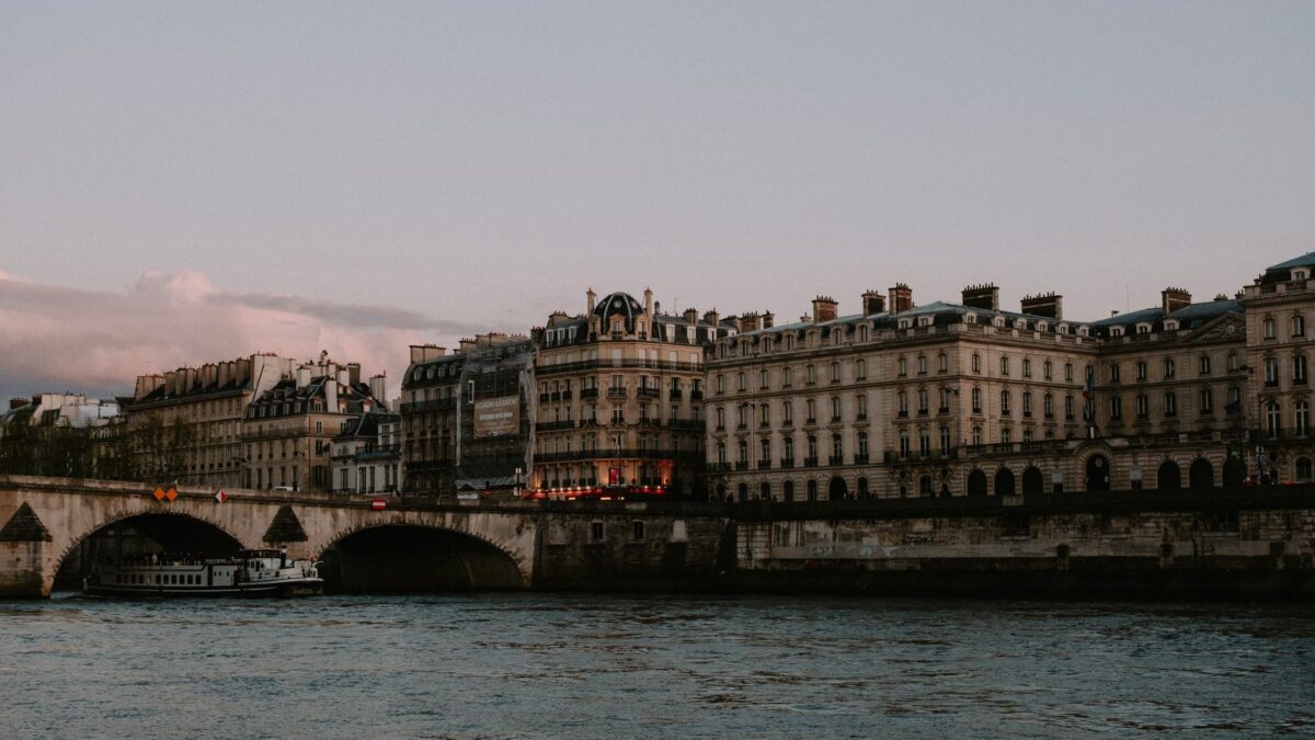 Charming view of historic buildings and bridge over the Seine River in Paris at dusk.