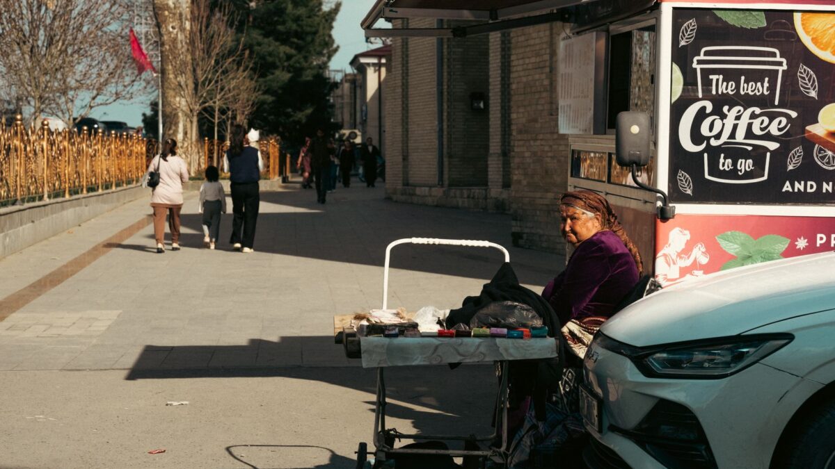 Street life in Uzbekistan featuring a local vendor by a coffee stand. Captivating cultural scene.