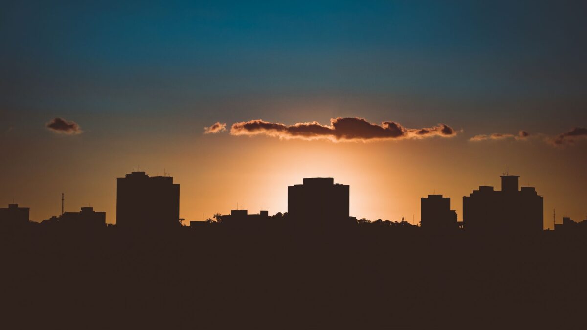 Dramatic city skyline silhouette with backlit sun during golden hour creating a stunning silhouette.