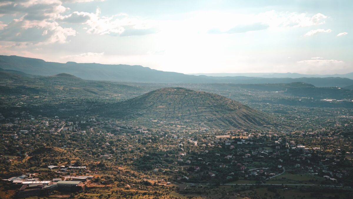 A breathtaking aerial view showcasing a scenic mountainous valley landscape with a sprawling town.
