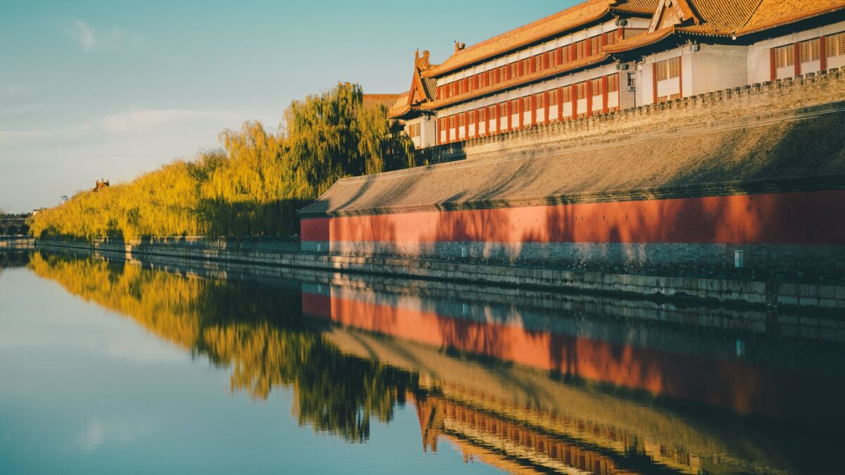 Golden sunset reflects on the historic Forbidden City walls in Beijing, China.