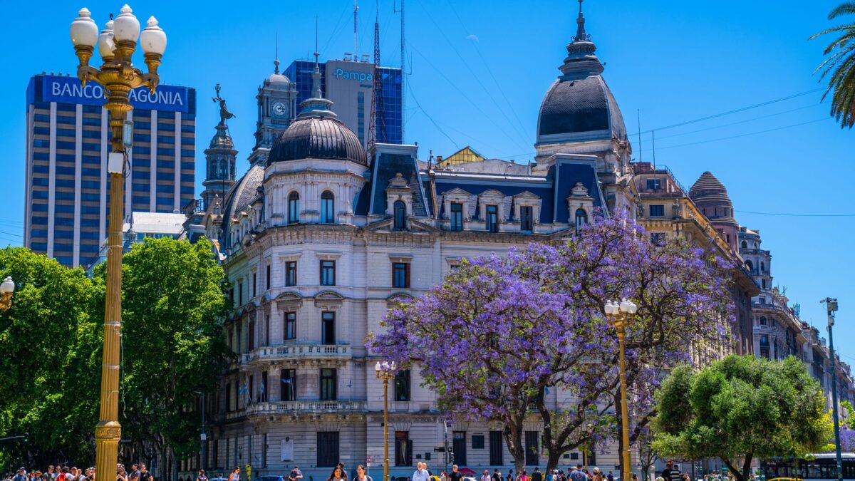 Street view of Plaza de Mayo with iconic buildings and jacaranda trees in Buenos Aires, Argentina.
