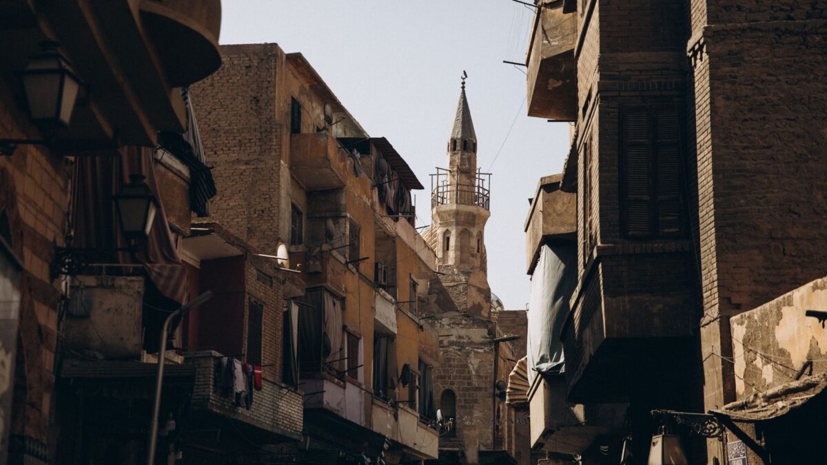 Narrow street in Cairo featuring historic Islamic architecture and urban life.