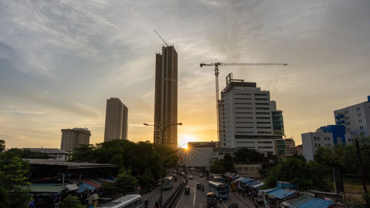A vibrant view of Colombo's skyline at sunset showcasing towering skyscrapers and bustling streets.