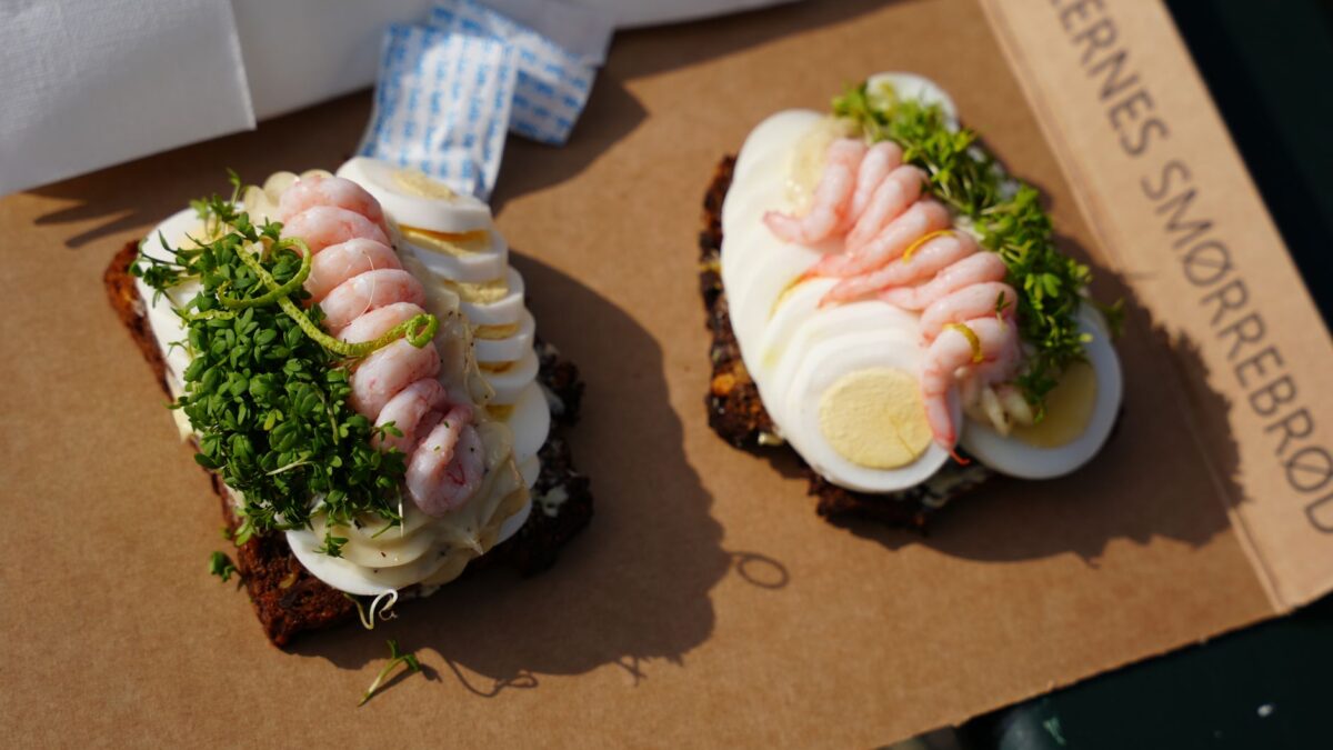 Traditional Danish smørrebrød with shrimp, eggs, and herbs on rye bread in Copenhagen.