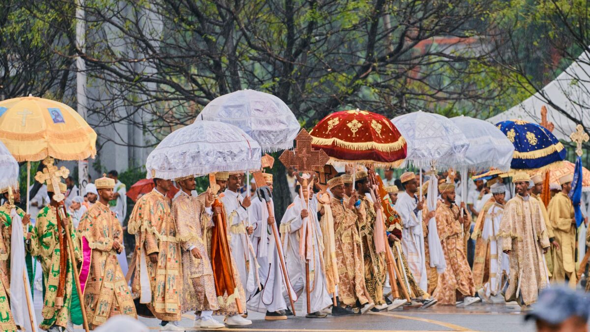 Vibrant Ethiopian religious procession with umbrellas in a ceremonial parade.