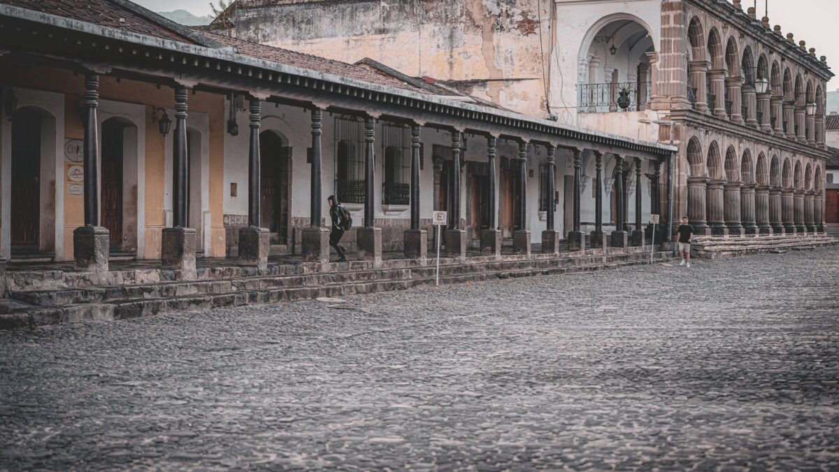 Elegant colonial buildings with stone archways and cobblestone streets in Antigua Guatemala.
