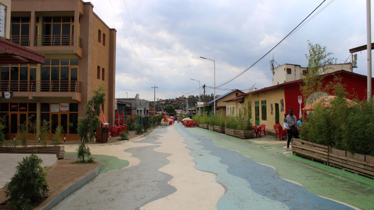 Dynamic street scene in Nyamirambo, Kigali with colorful architecture and vibrant patterns.
