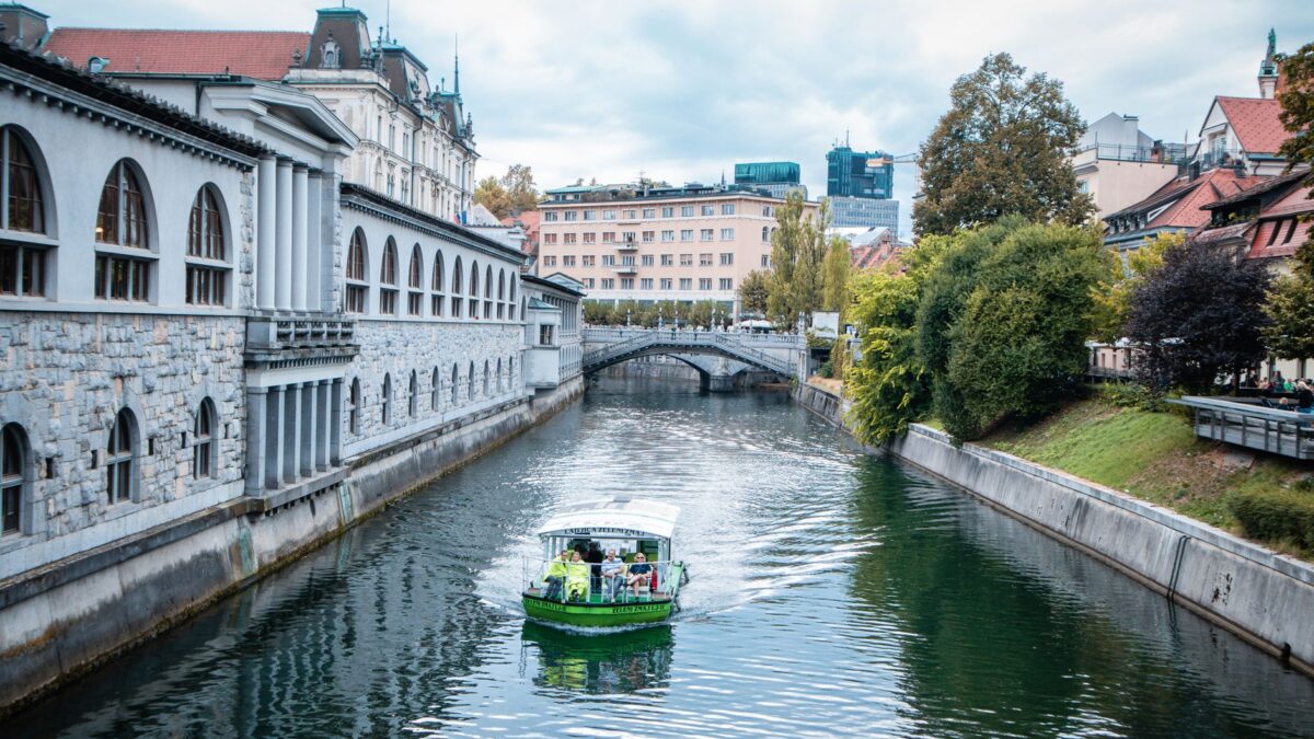 Explore a scenic view of a canal with a boat in Ljubljana, Slovenia.