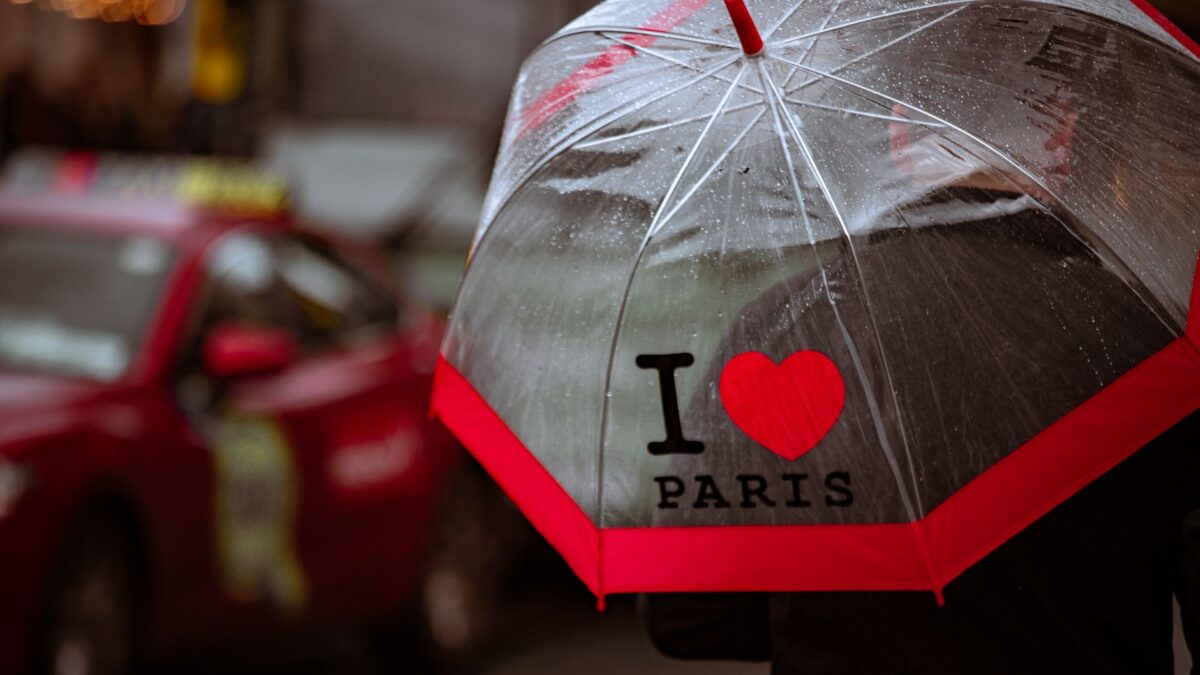 A rainy day in Dublin featuring an 'I Love Paris' umbrella and a red taxi.