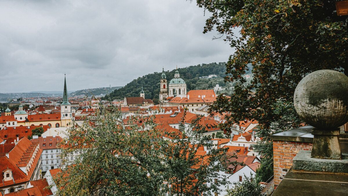 Explore the stunning skyline of Prague with red rooftops and historical architecture.