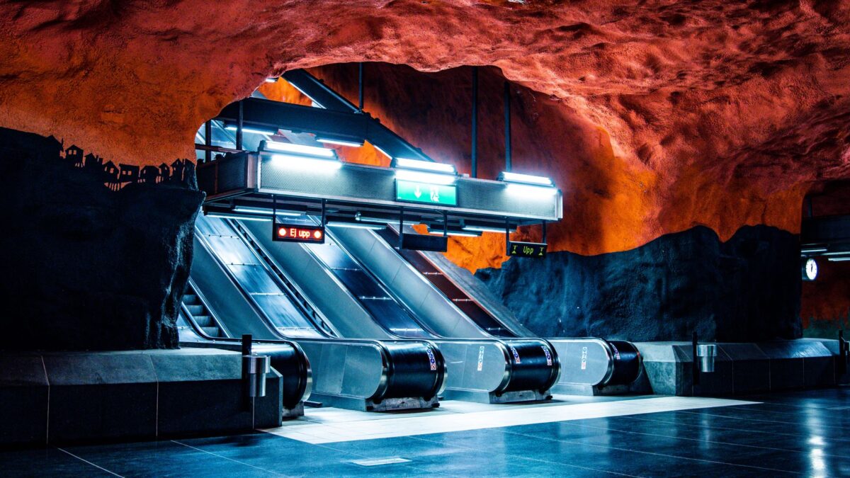 Artistic Stockholm subway station with cave-like walls and escalators.